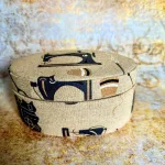 Eine ovale Dose mit Nähmaschinenmotiv