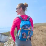 Frau mit türkisem, floralem Rucksack beim Wandern